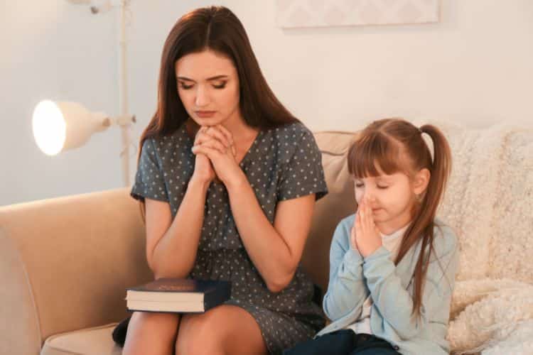 mãe orando com filha