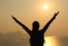 Mulher levantando as mãos representando a liderança de Débora em Juízes