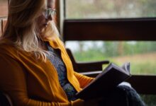 Mulher com bíblia na mçao lendo Versículo do Dia Motivacional