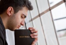 Homem segurando a Bíblia com expressão de gratidão simbolizando fé em versículos de gratidão por servir a Deus